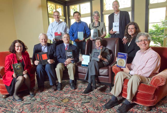 Faculty sitting together holding up their books