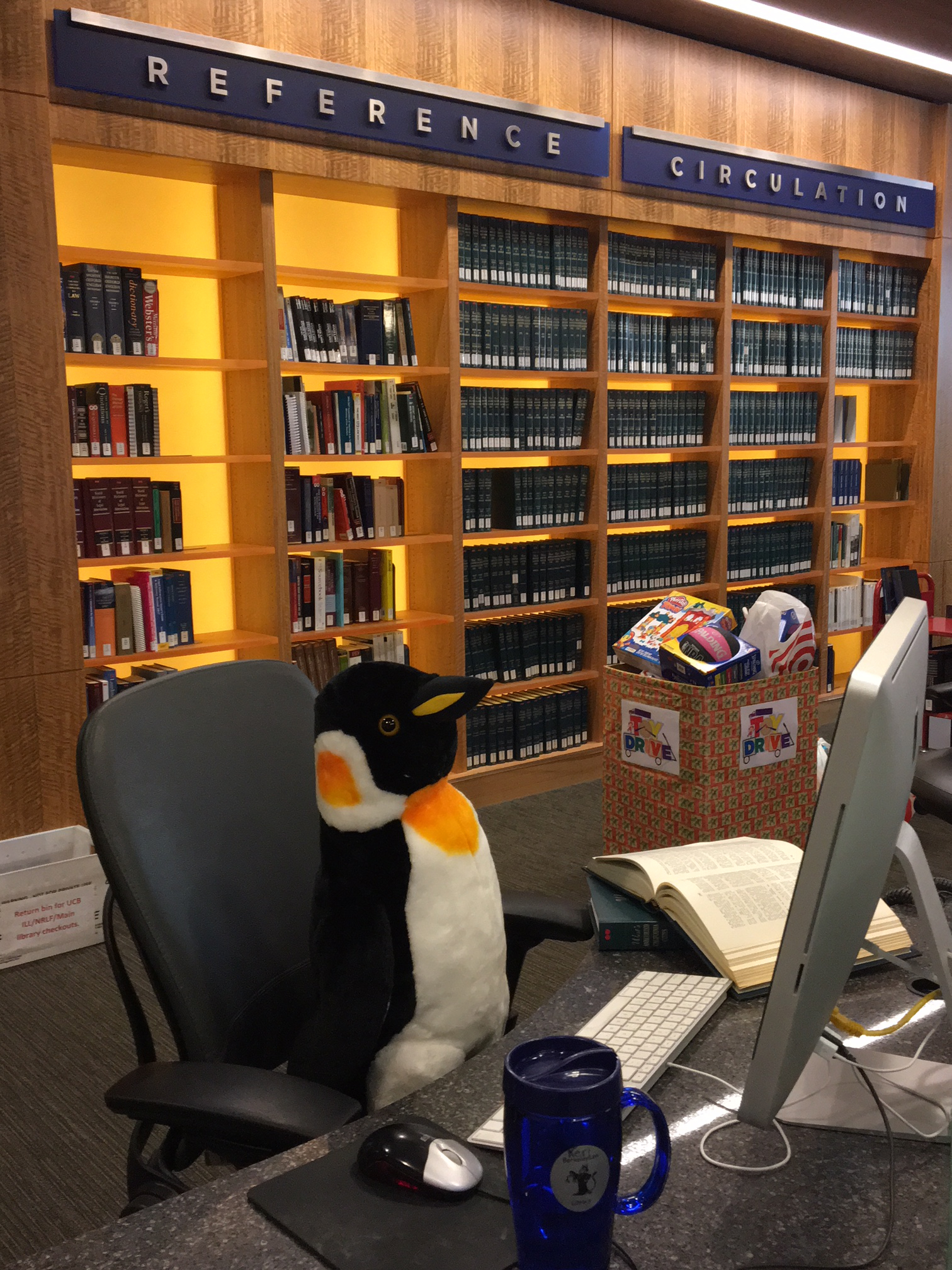 Penguin sitting at the Reference Desk