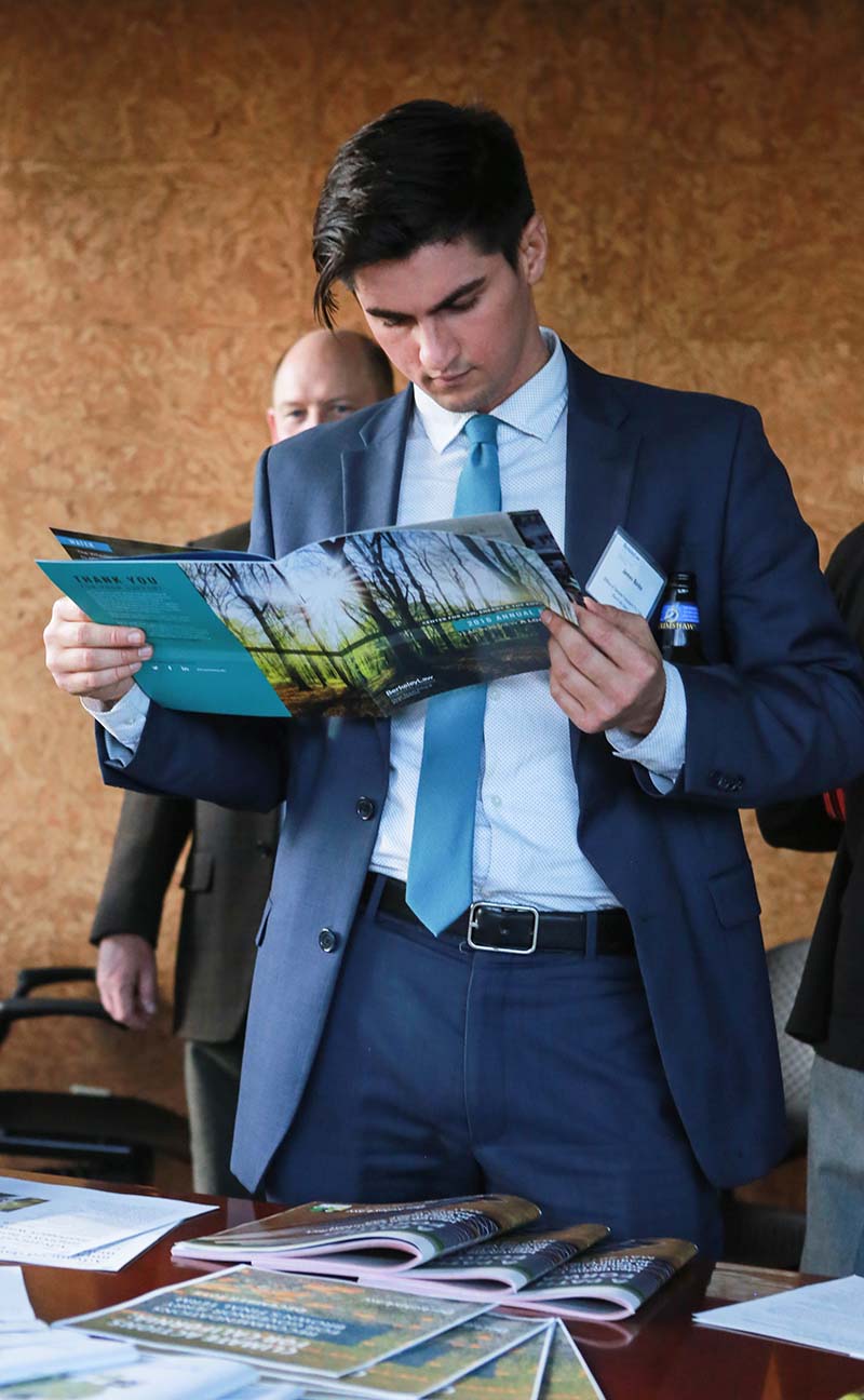 A guest peers over the 2016 Annual Report at a CLEE event.