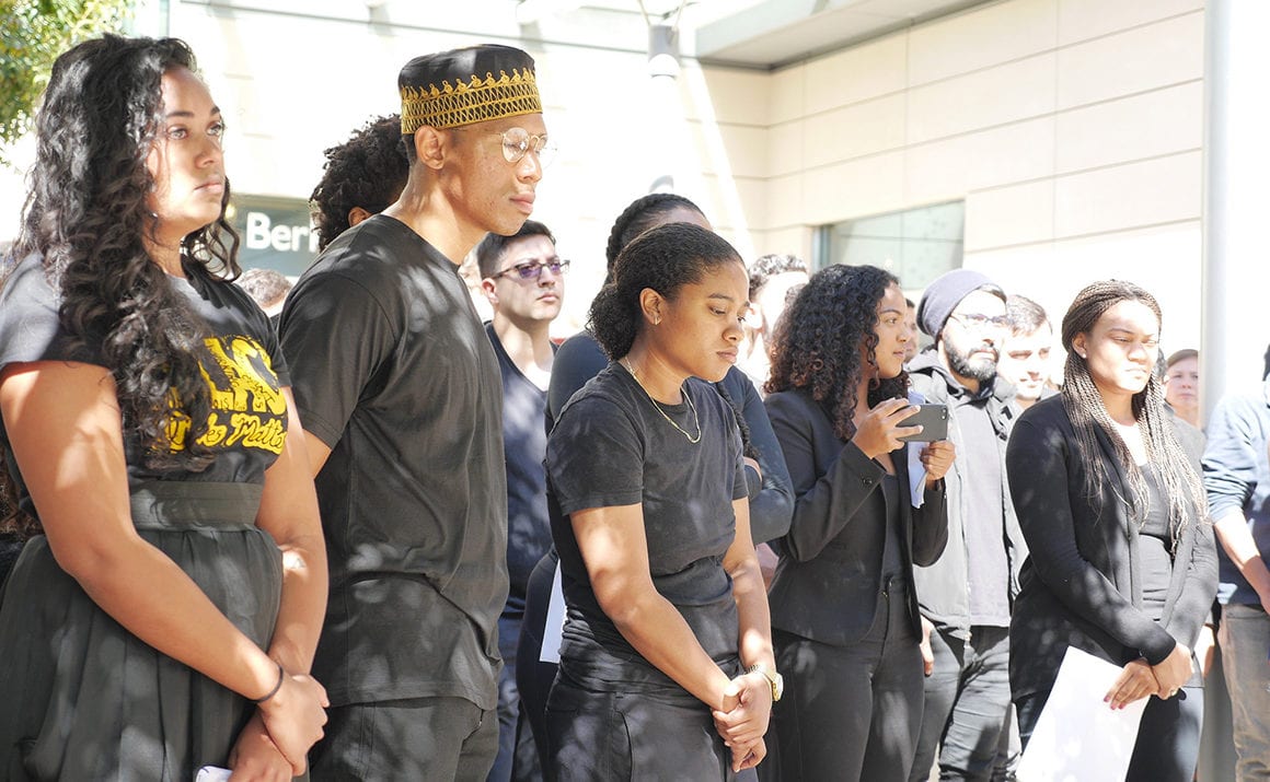 People dressed in black standing somberly at an event