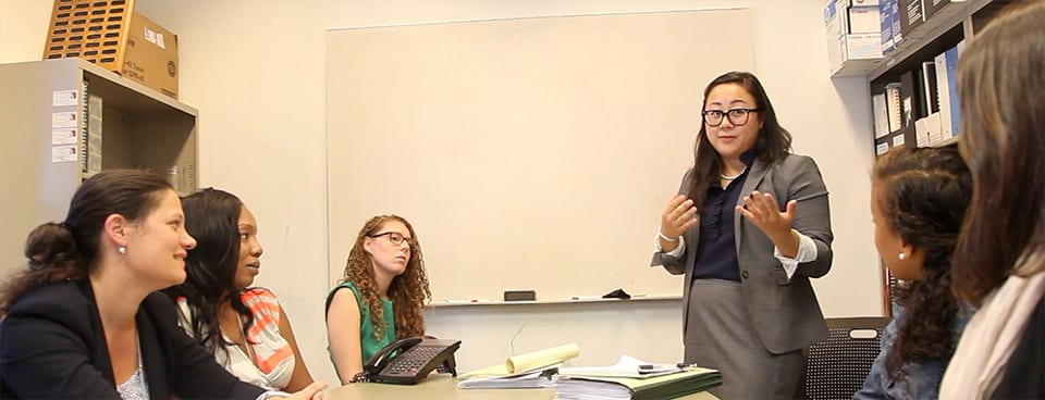 Cristina Sepe '15 discusses case strategy with Youth Defender Clinic Director Kate Weisburd (left), administrative assistant Tamura Rosby, and two other clinic students.