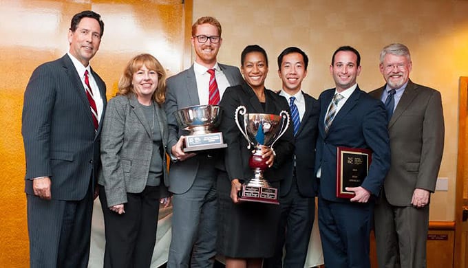 National Civil Trial Competition champions Colin Jones '16 (third from left), DeCarol Davis '17, Jason Wu '16, and Jared Ginsburg '17 with judges panel member Geoff Wells, competition founder Susan Poehls, and Loyola Law School Dean Paul Hayden.