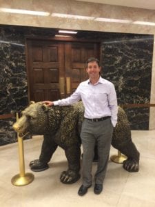 Climate Program Director Ethan Elkind poses in front of the bronze grizzly bear at the California Office of the Governor.