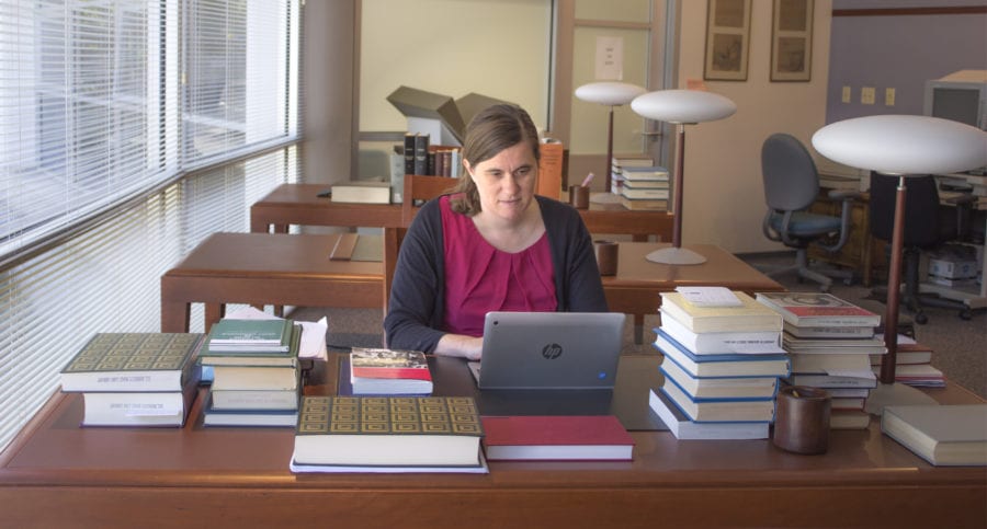 Former Robbins Collection Fellow, Agnès Desmazières, sitting at a desk in the library reading room.