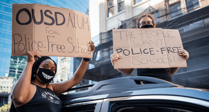 masked women holding protest signs