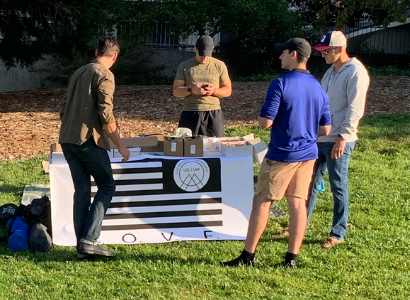 men standing around an outdoor table