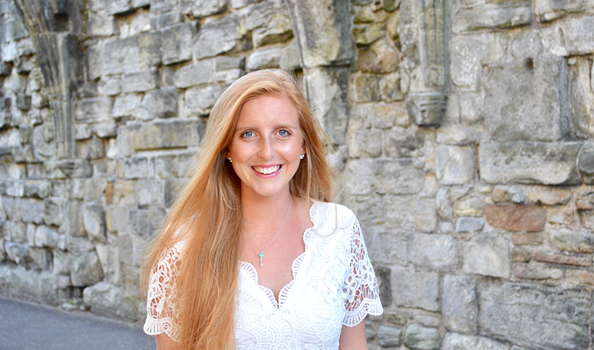 Julia Bennett posing in front of stone wall