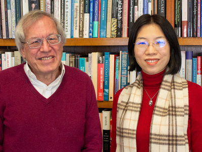 man and woman smiling in front of bookshelves
