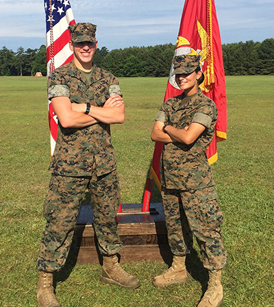 Lulu Mansour and Stephen Voto in uniform with flags on green field