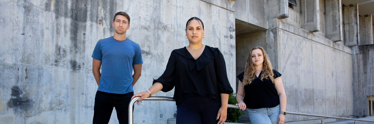 Three Death Penalty Clinic students standing in front of building