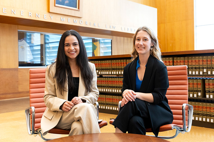 Leila Nasrolahi and Kate Walford sitting in library smiling