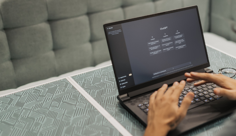 hands hovering over laptop with chatgpt application on screen