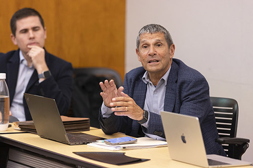 Richard Brand speaking while seated at conference table