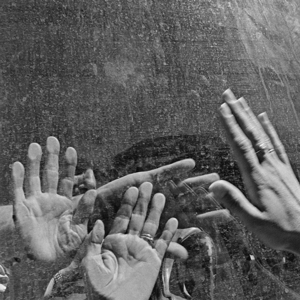 Hands reaching up to vehicle window